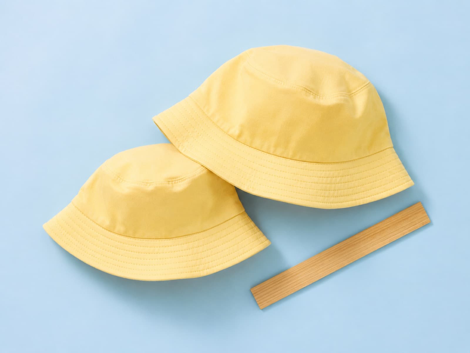 A toddler bucket hat and an adult bucket hat laid side by side